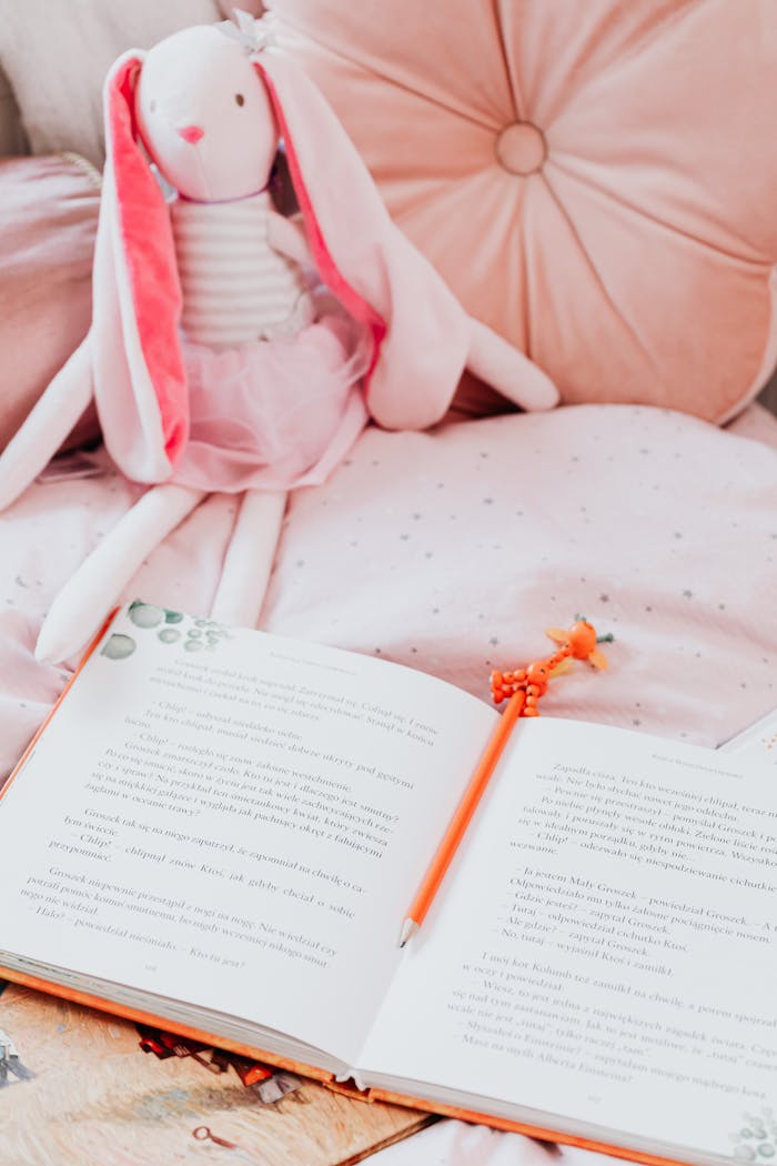 Pink-themed cozy bedroom setup with a stuffed toy, open book, and cute decor.